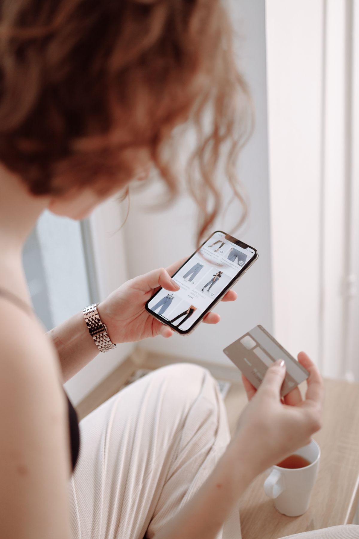 A person using a smartphone beside a credit card