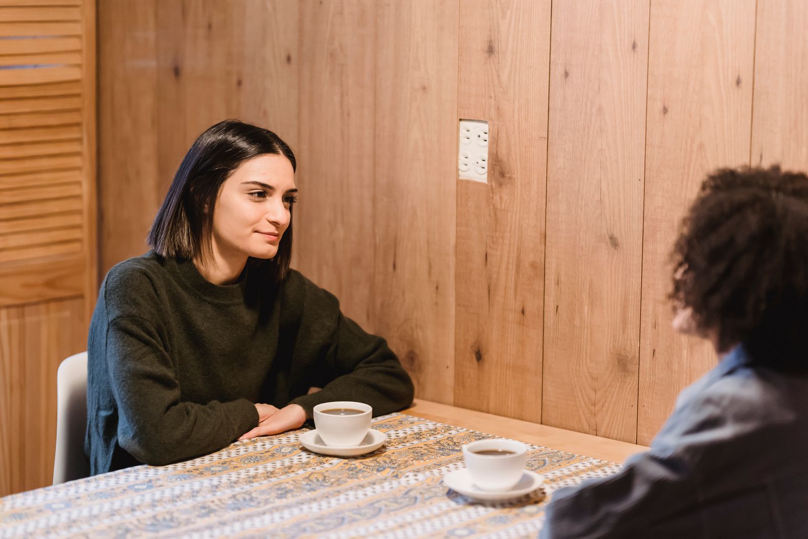 Two people sharing coffee across a table