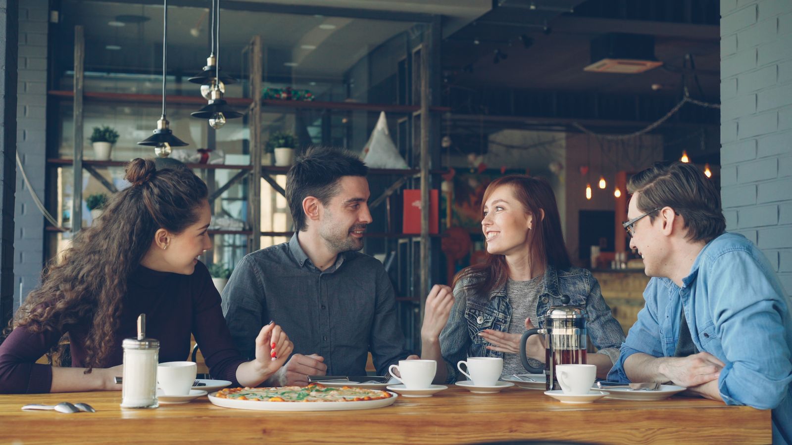 Friends talking together over coffee at a table