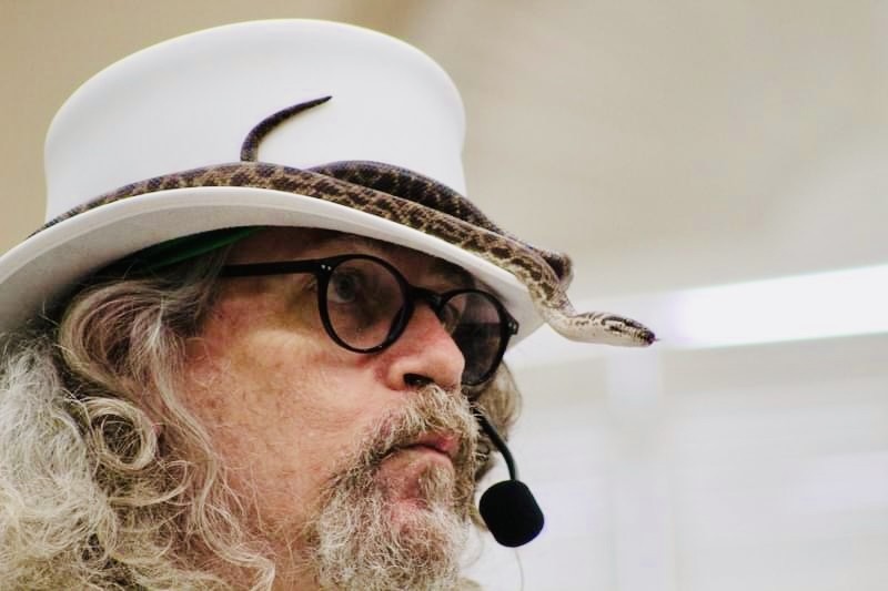 Daryl Sprout performing with a snake and headset microphone