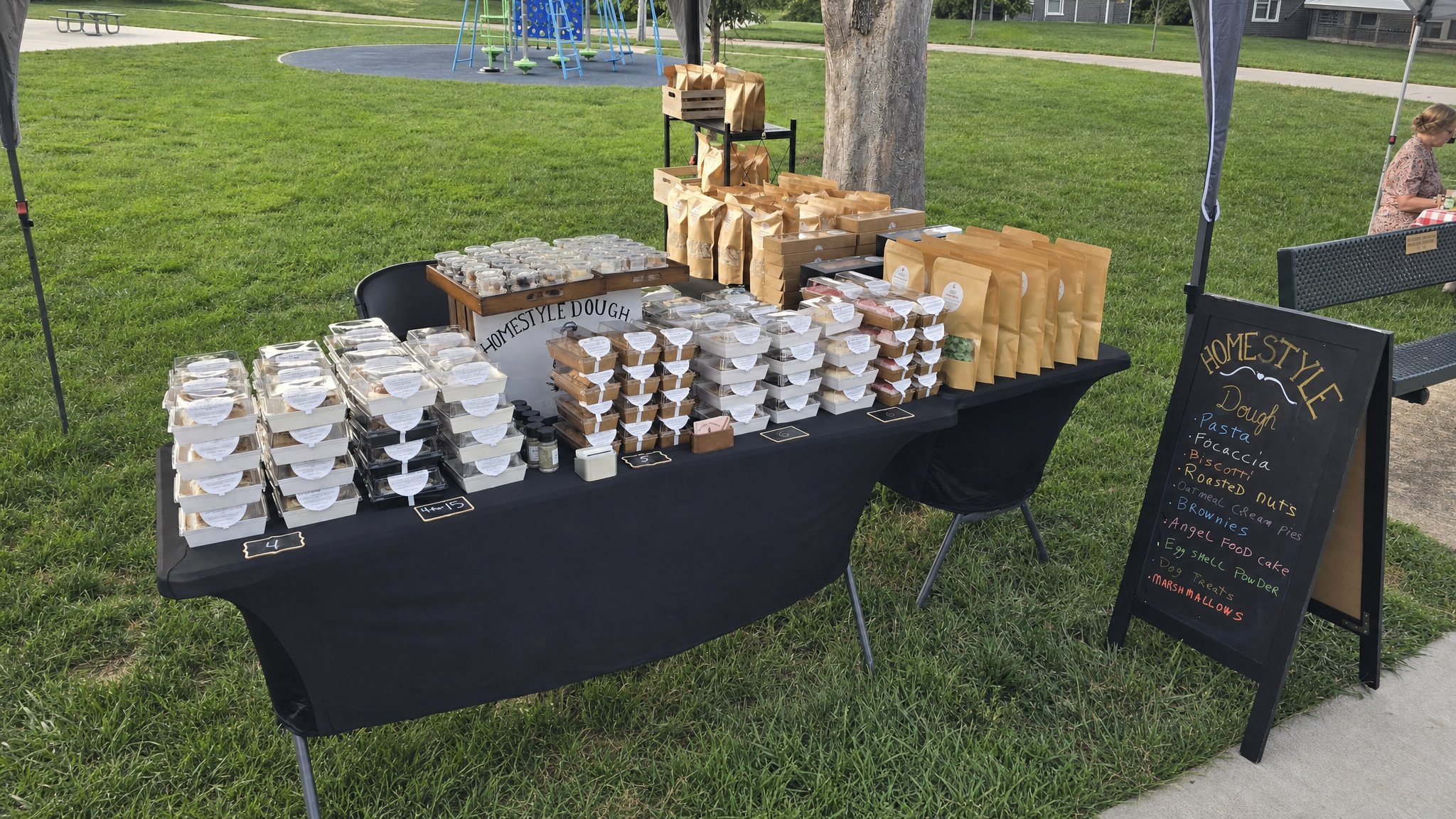 Homestyle Dough table filled with baked goods at a farmers market