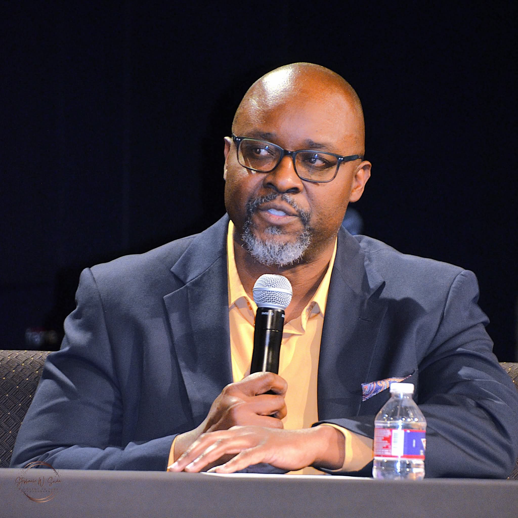 Senior Pastor Rodney LaBruce holding a microphone