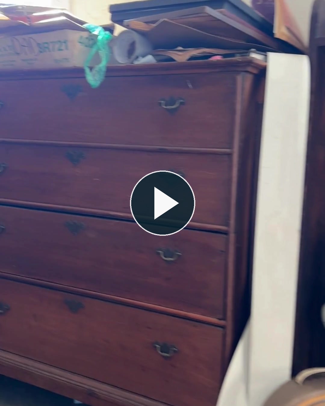 Video preview of a crowded antique room with a play button