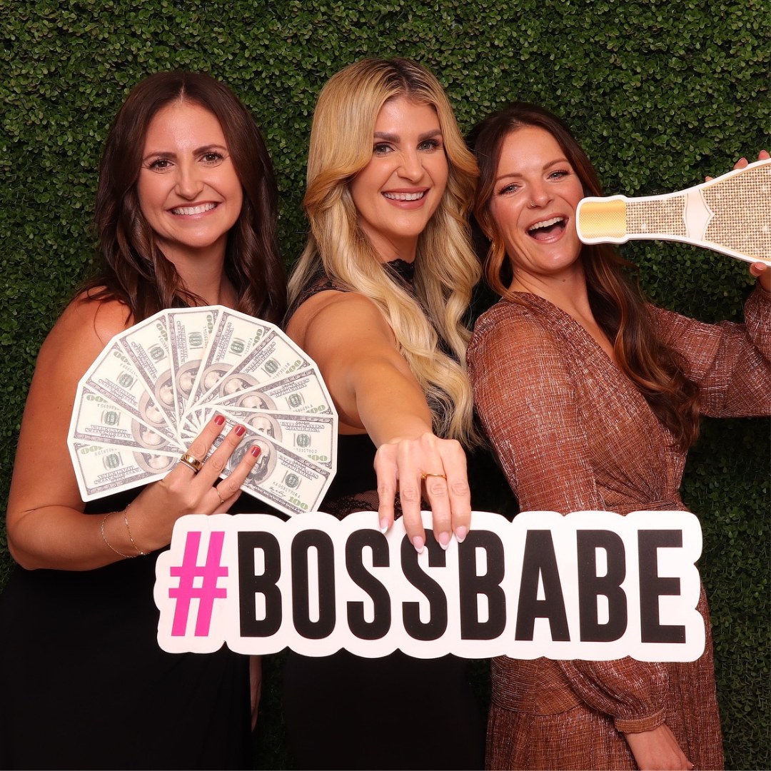 Guests posing with #BOSSBABE and champagne bottle props at a corporate photo booth rental in the Phoenix area