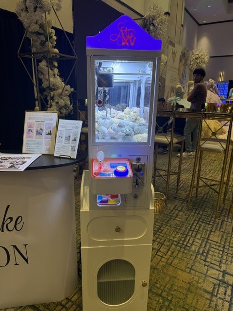 Mini claw machine rental filled with teddy bear keychains at a Phoenix-area quinceañera expo