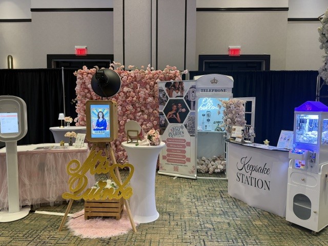 The Pose Garden quinceañera photo booth display with pink flower wall, telephone booth, keepsake station and claw machine near Phoenix, Arizona