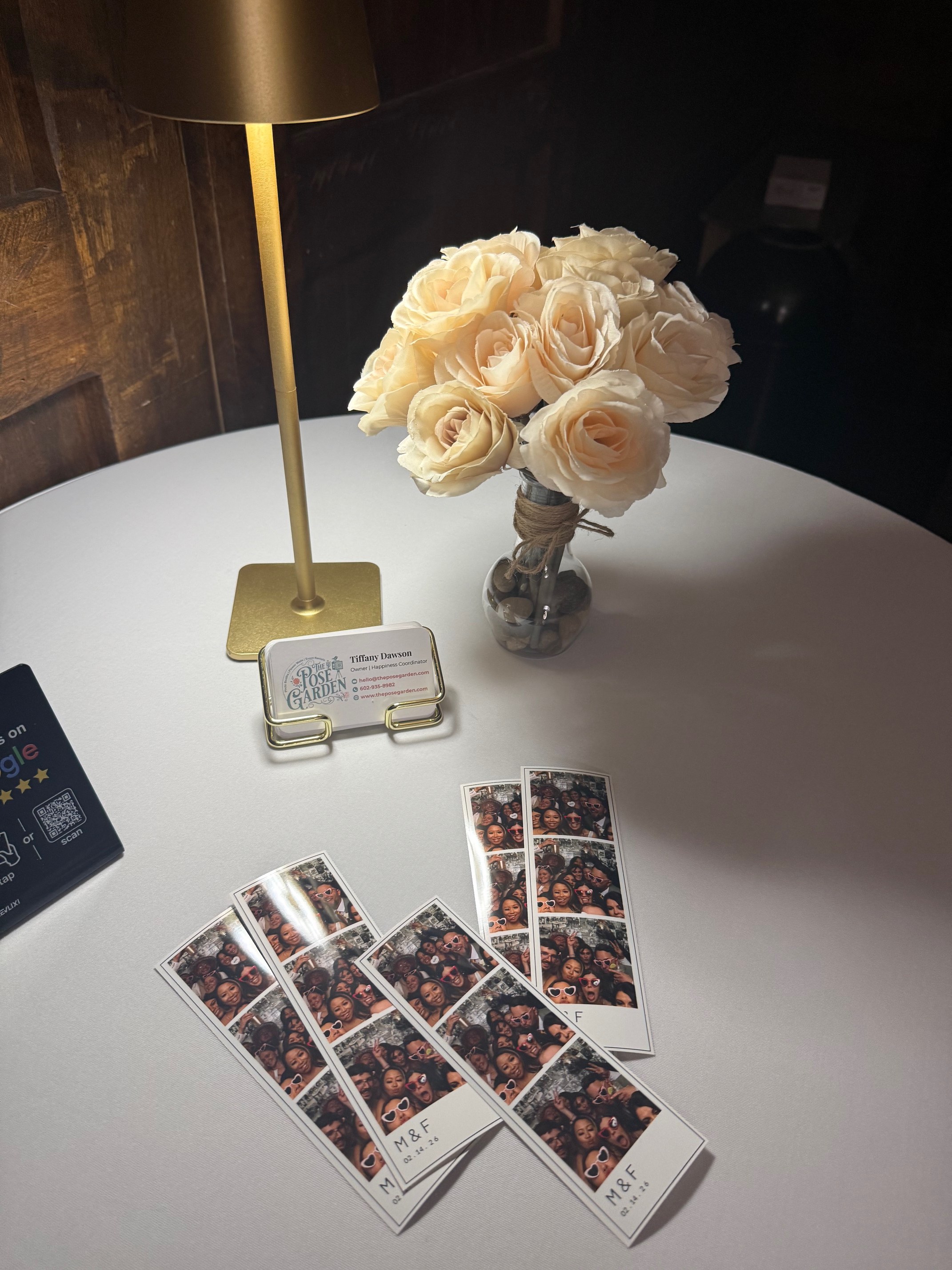 Wedding photo strips displayed beside a bouquet and lamp