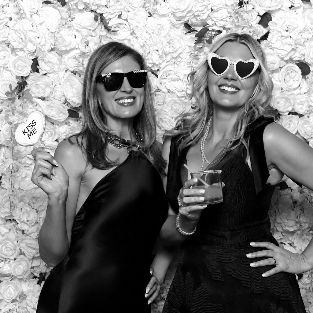 Wedding guests posing in front of a flower wall