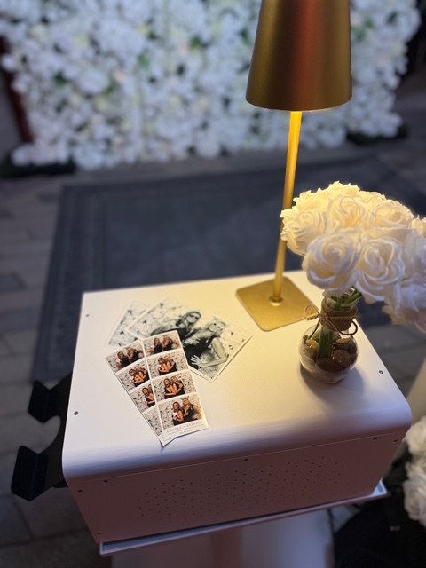 Wedding Photo Booth prints displayed beside a floral arrangement