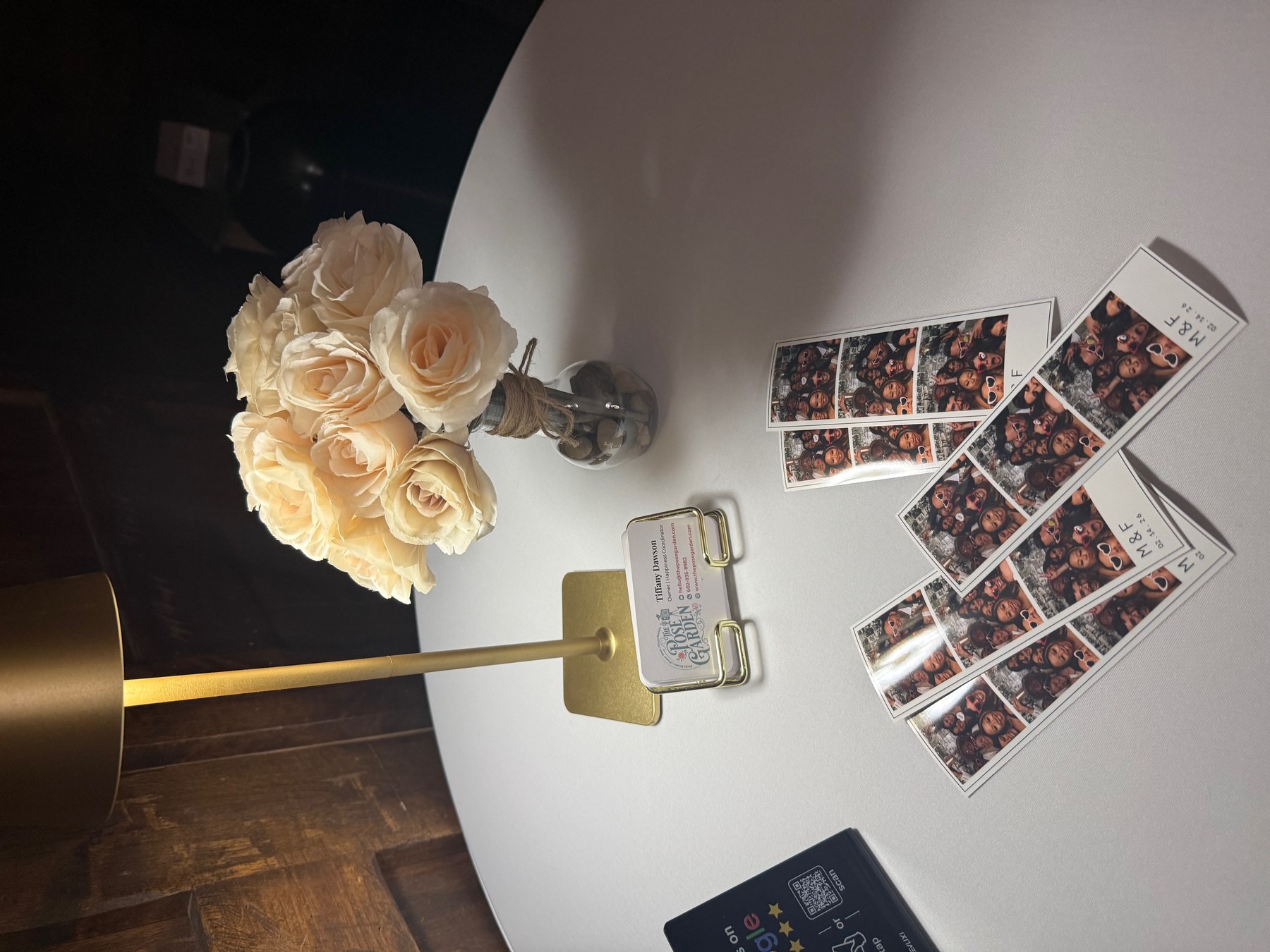 Photo booth prints displayed beside a wedding floral arrangement