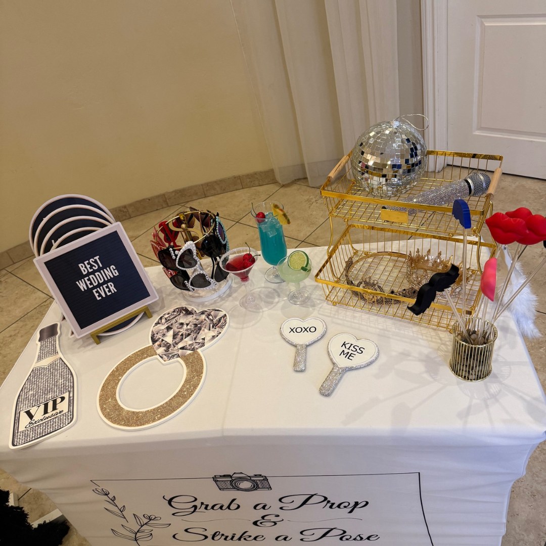 A wedding Photo Booth prop table with signs, sunglasses and small accessories