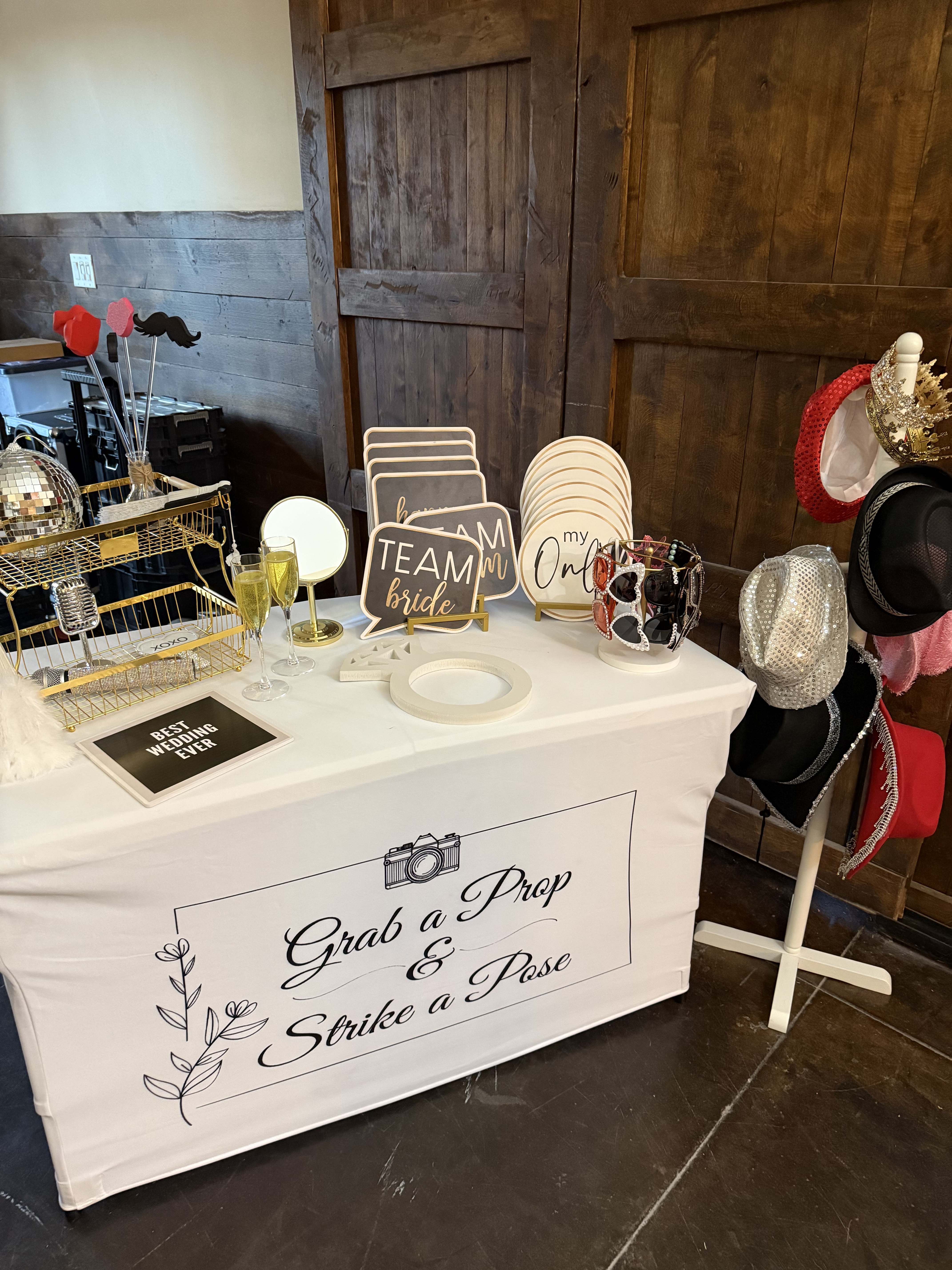 A neatly styled wedding Photo Booth prop table