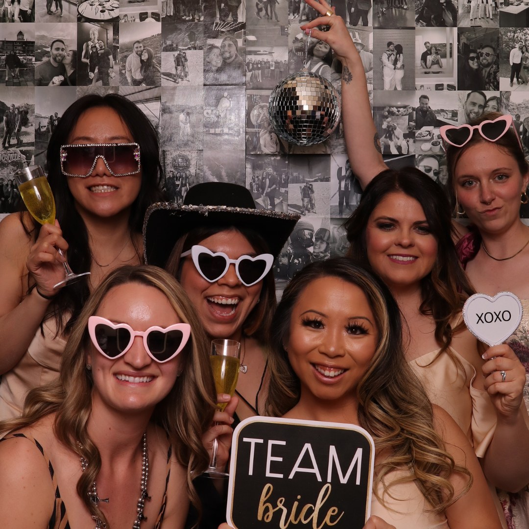 Wedding guests posing with sunglasses and Team Bride signs