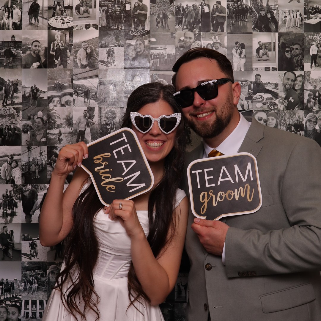 Bride and groom holding photo booth signs