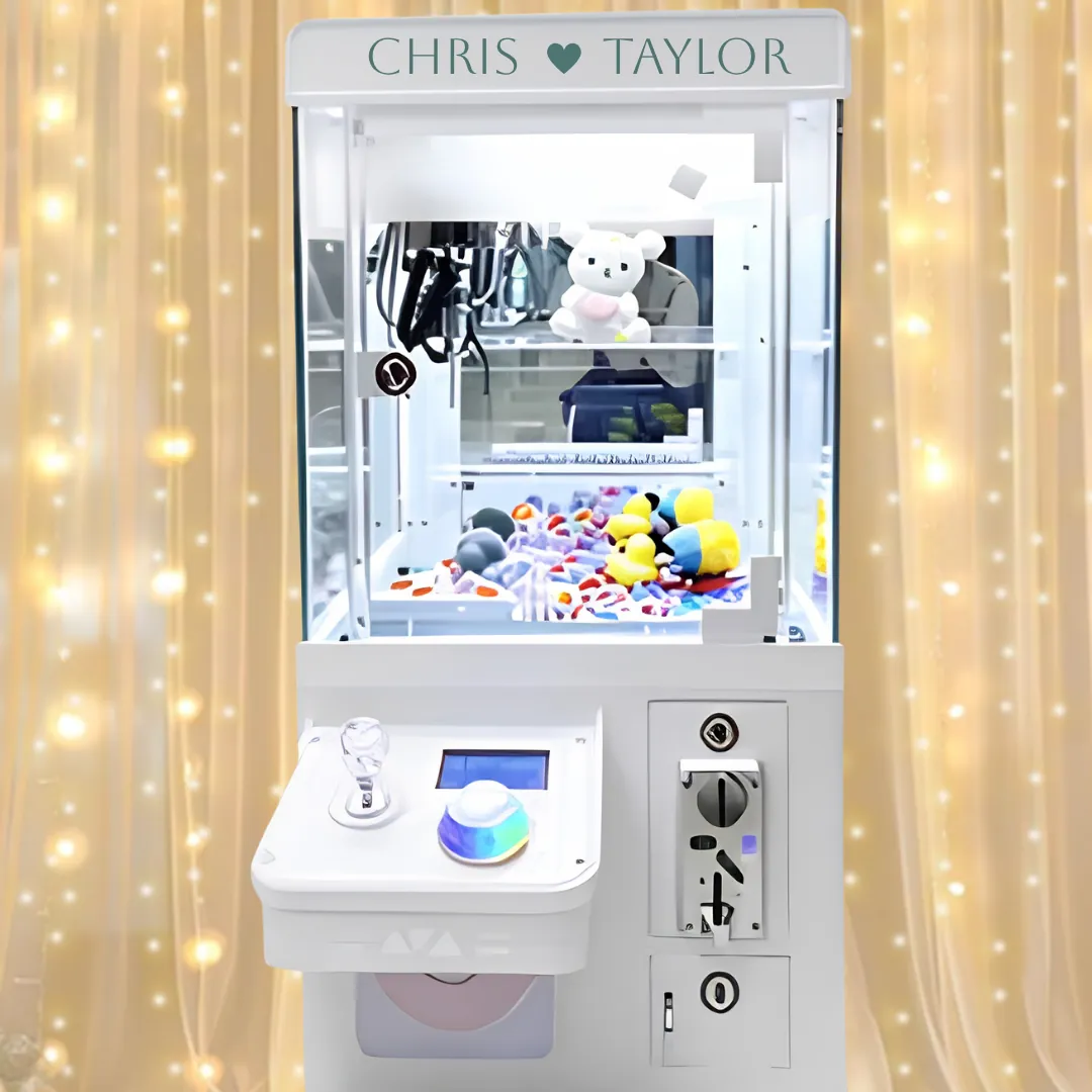 White wedding claw machine filled with plush prizes in front of a glowing gold backdrop