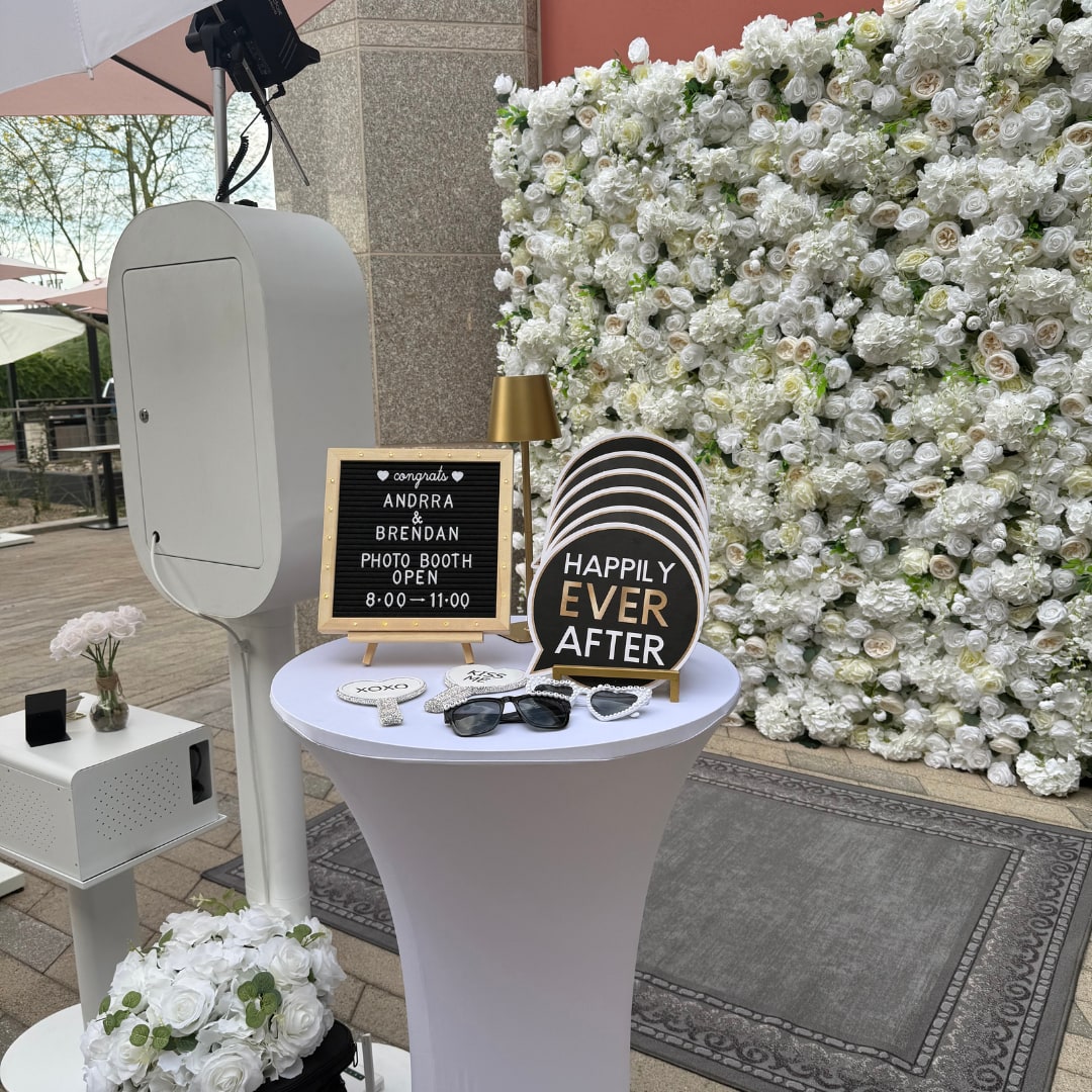 White Photo Booth, wedding props and a white flower wall at an outdoor wedding reception
