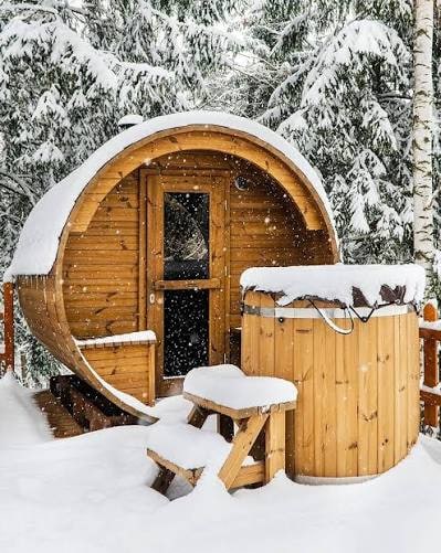 Round outdoor sauna in a snowy setting