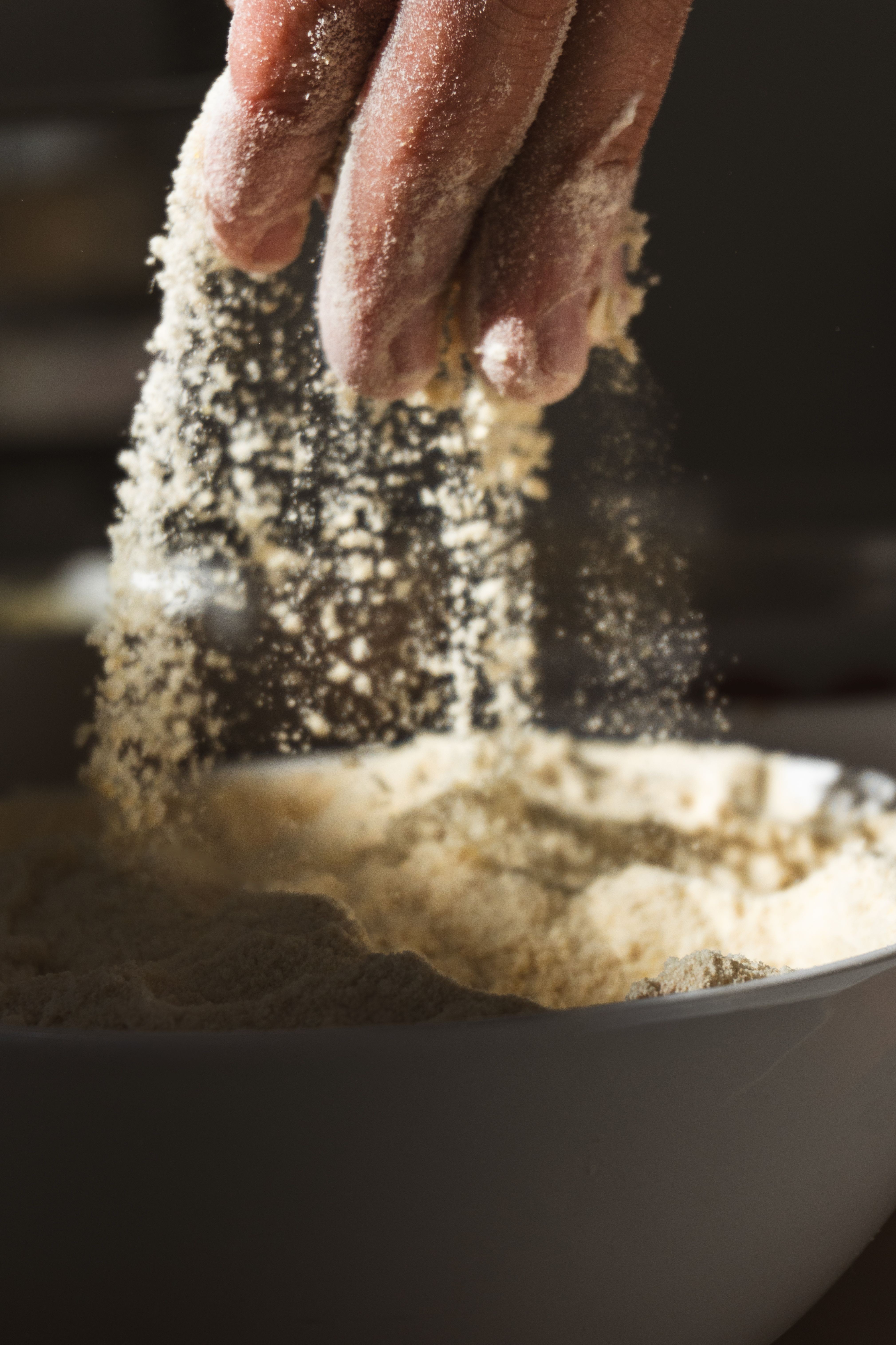 Flour-dusted hands working dough in the bakery