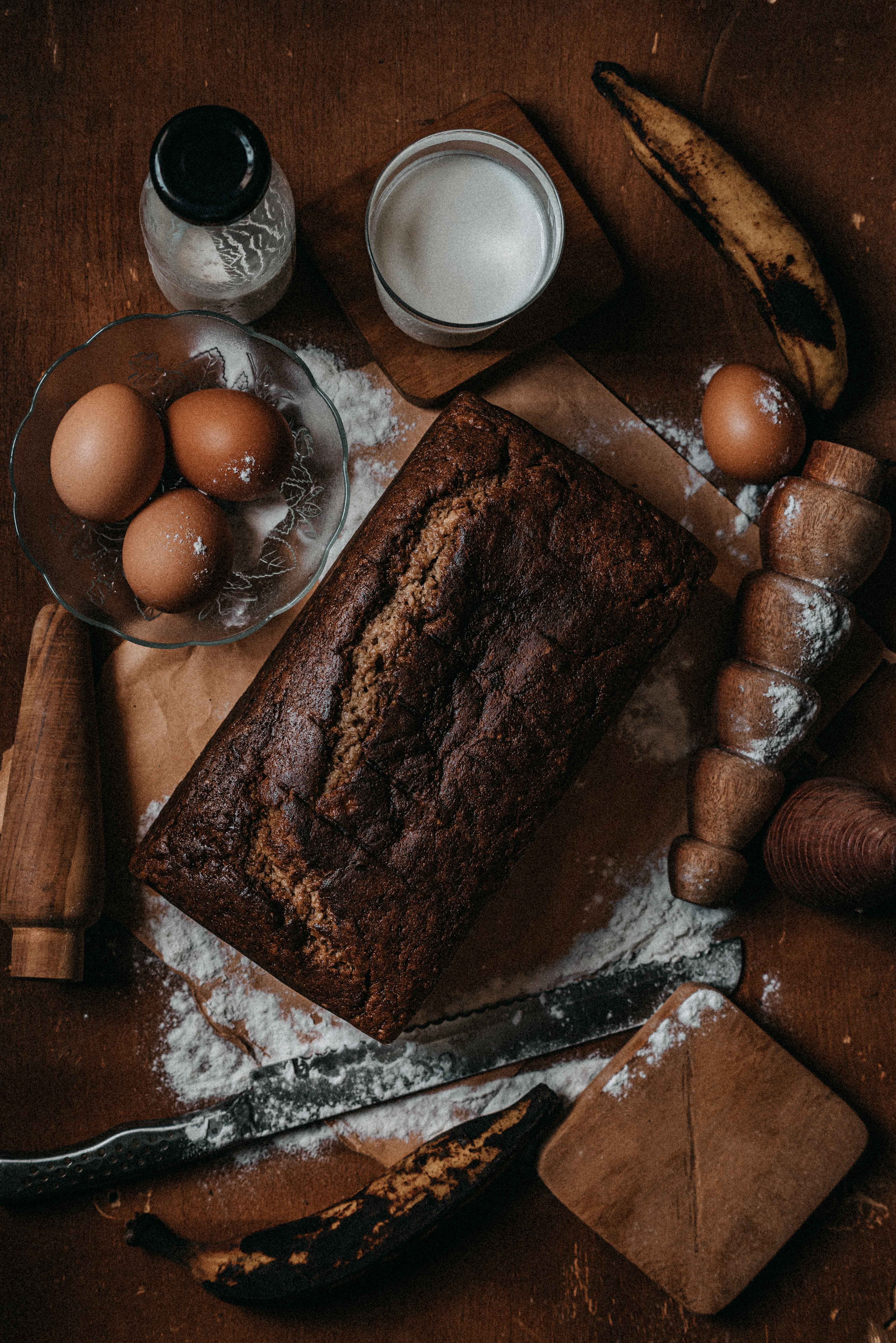 Banana bread ingredients and a baked loaf on a kitchen table