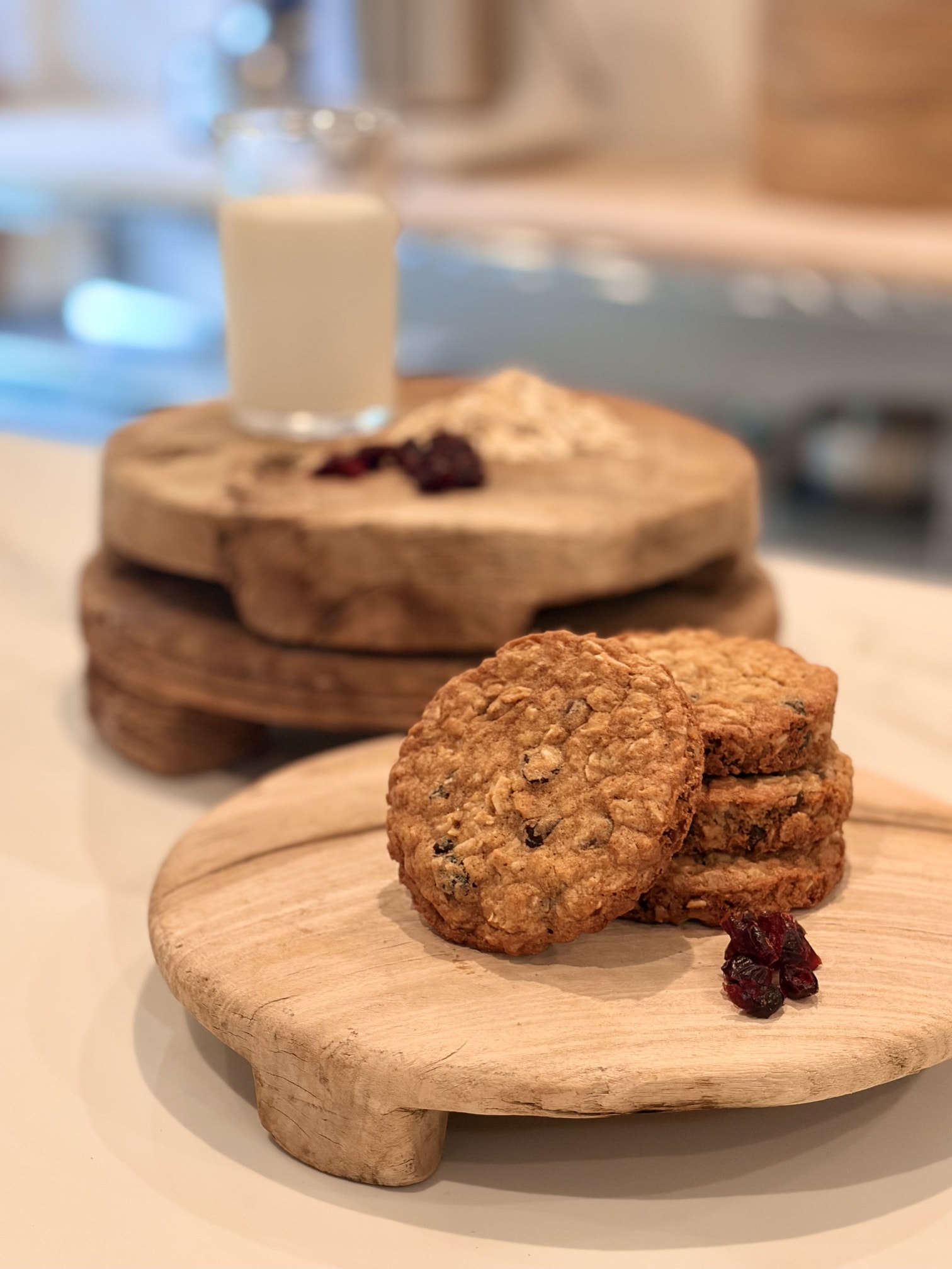 A stack of cowboy cookies with oats, chocolate, and cranberries on a wooden board