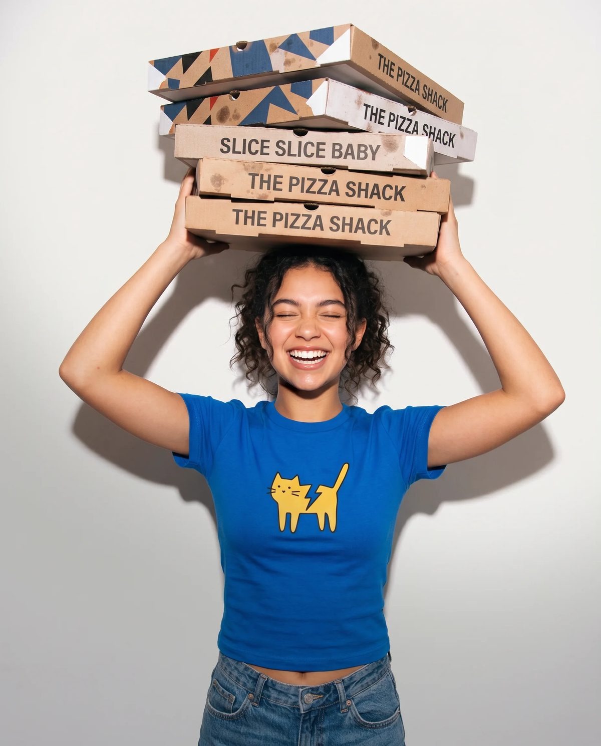 A student opening a pizza box at a school lunch table
