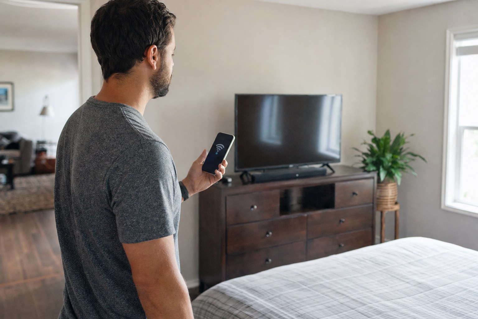 Household member checking Wi-Fi near a bedroom television