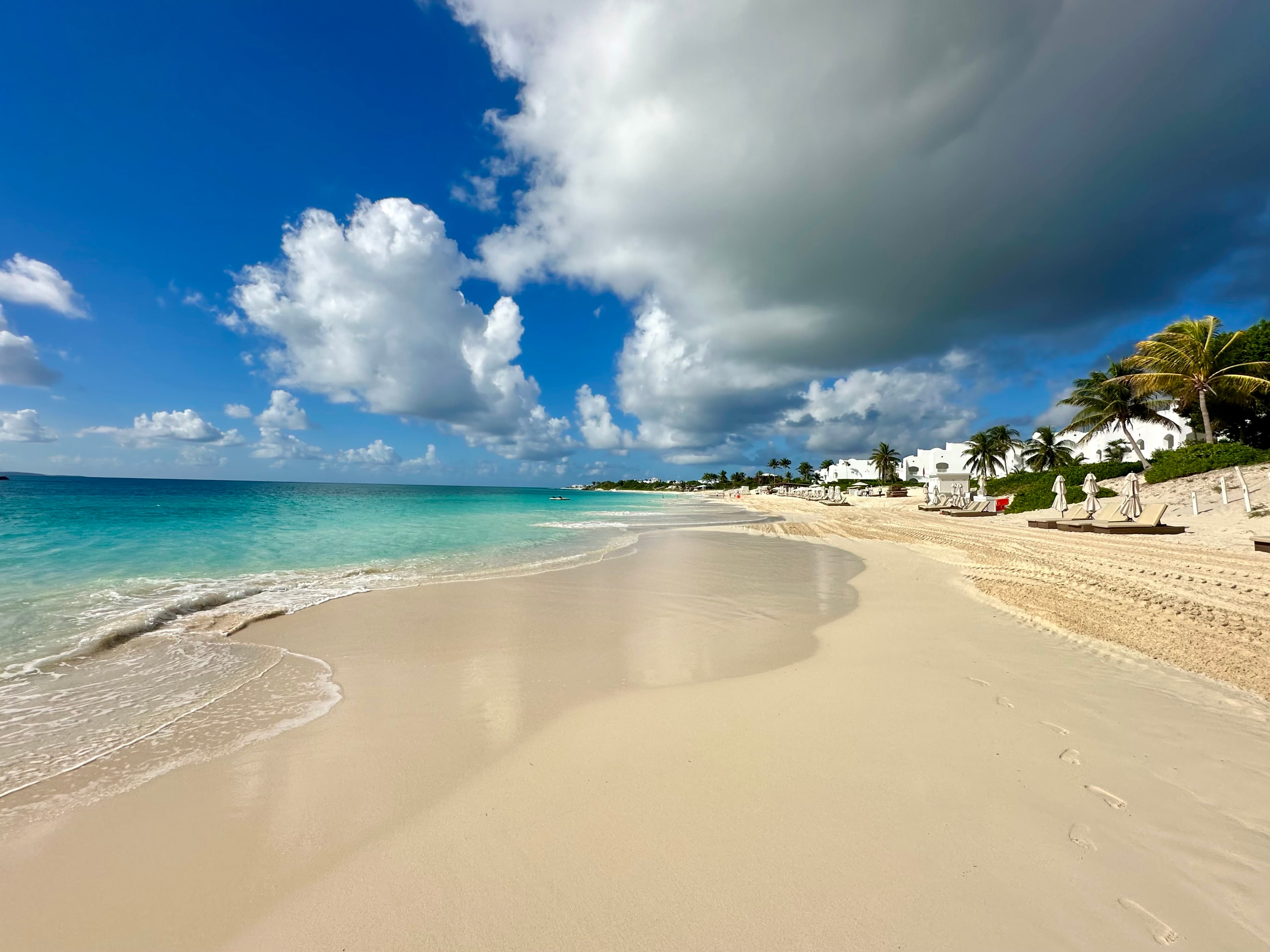 Two people walking along Anguilla's white-sand shoreline