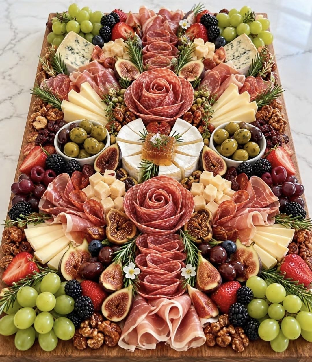 Custom charcuterie board with salami roses, cheeses, grapes, berries, and olives