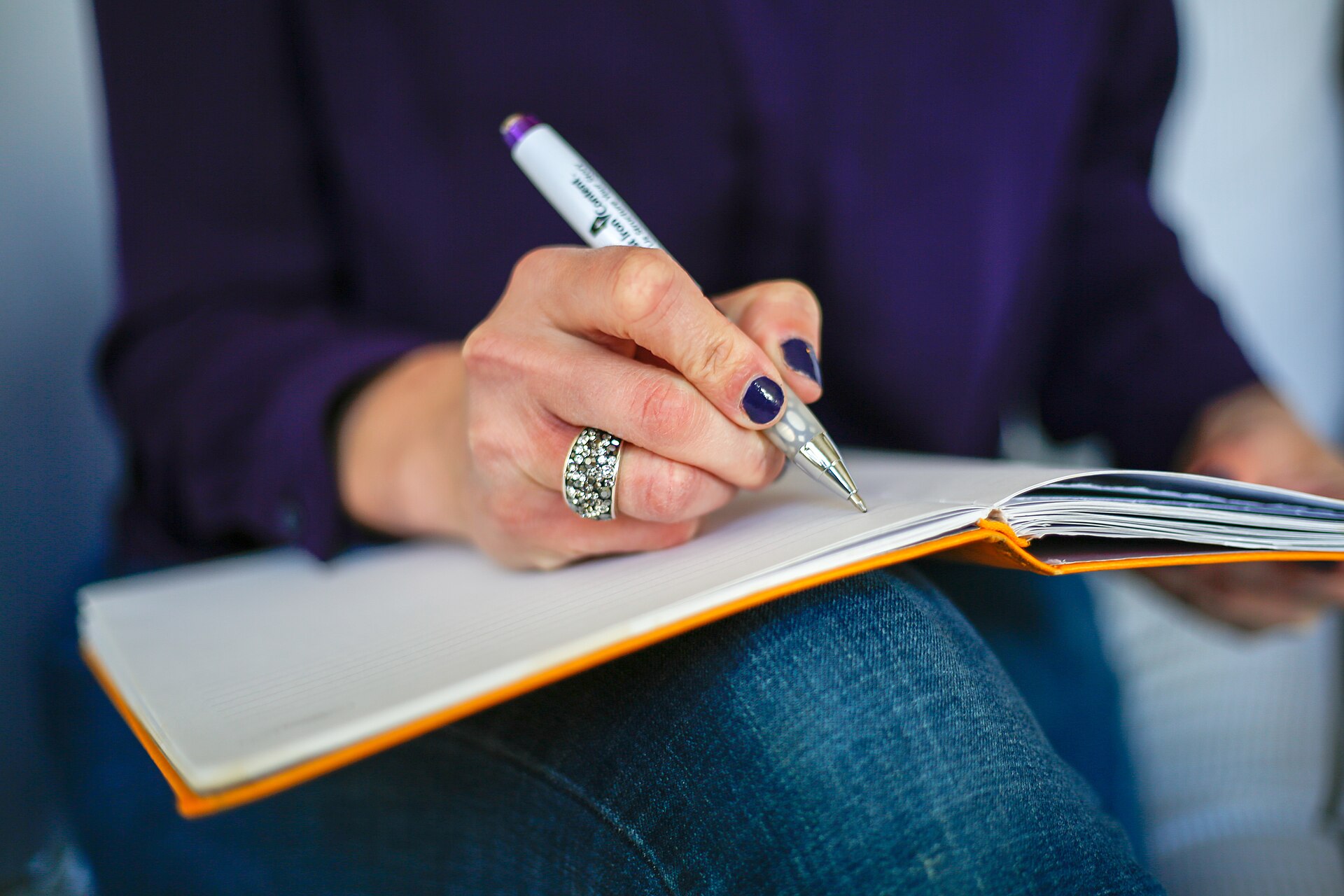 A person writing a reflection in a notebook