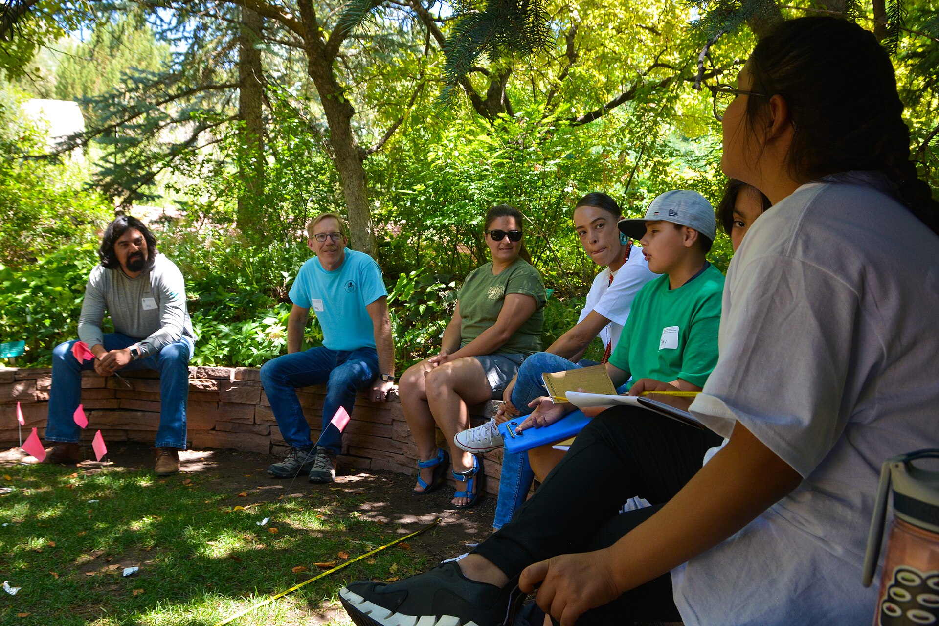 People gathered in a thoughtful outdoor conversation