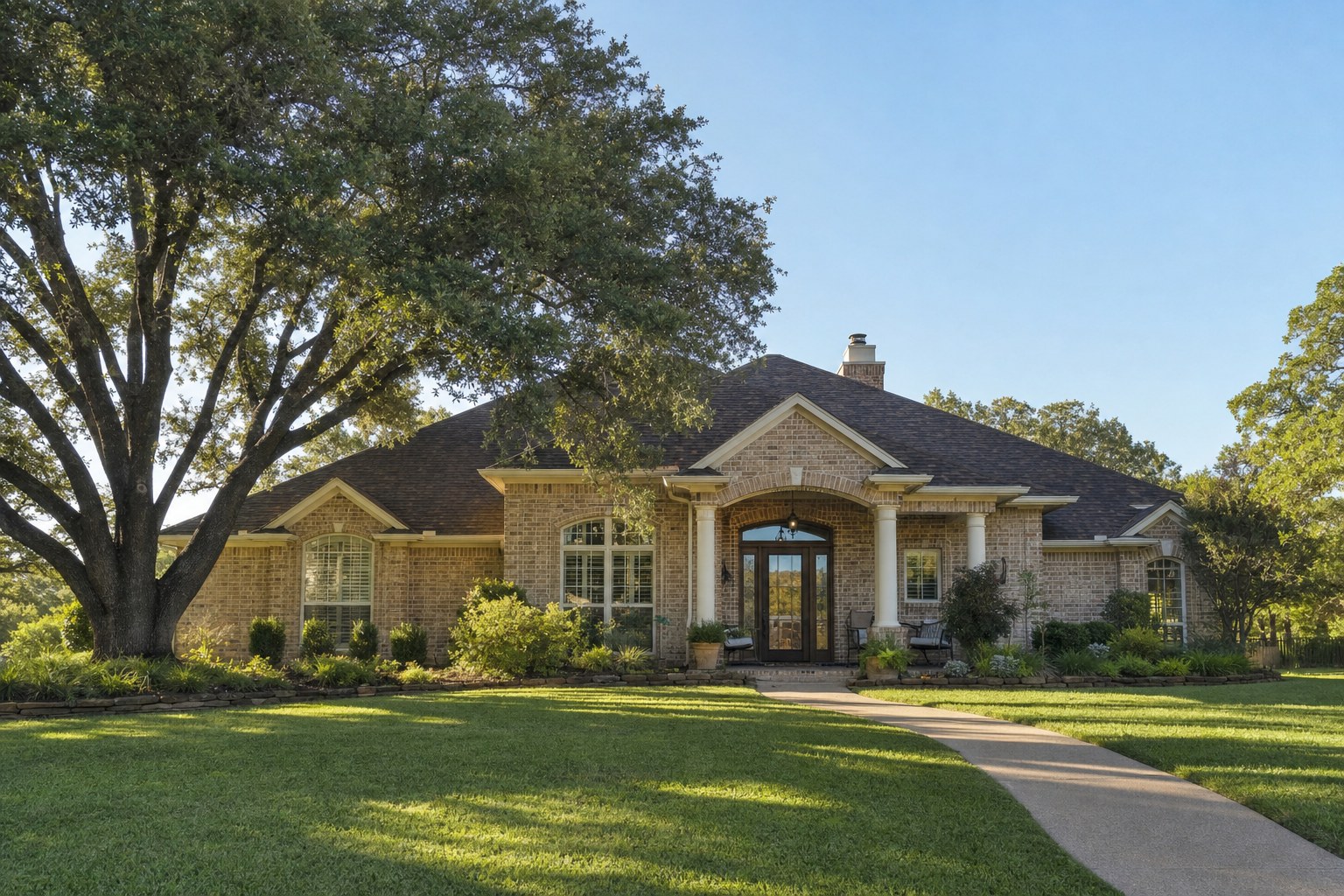 Texas brick home beneath a live oak