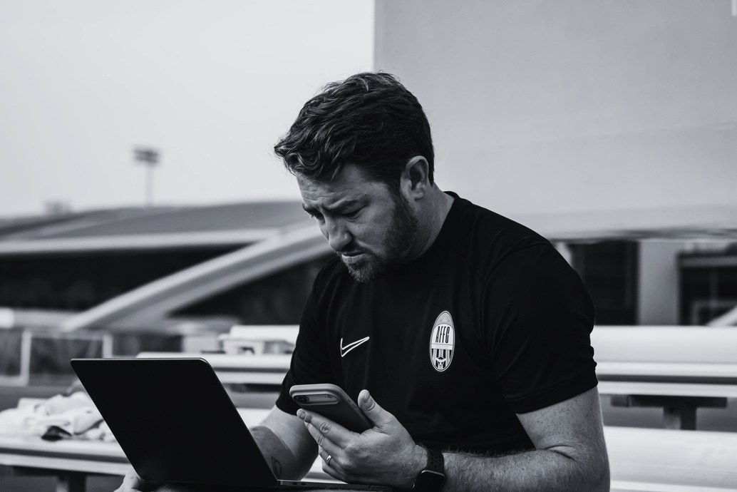 Arabian Falcons staff member reviewing player information on a laptop