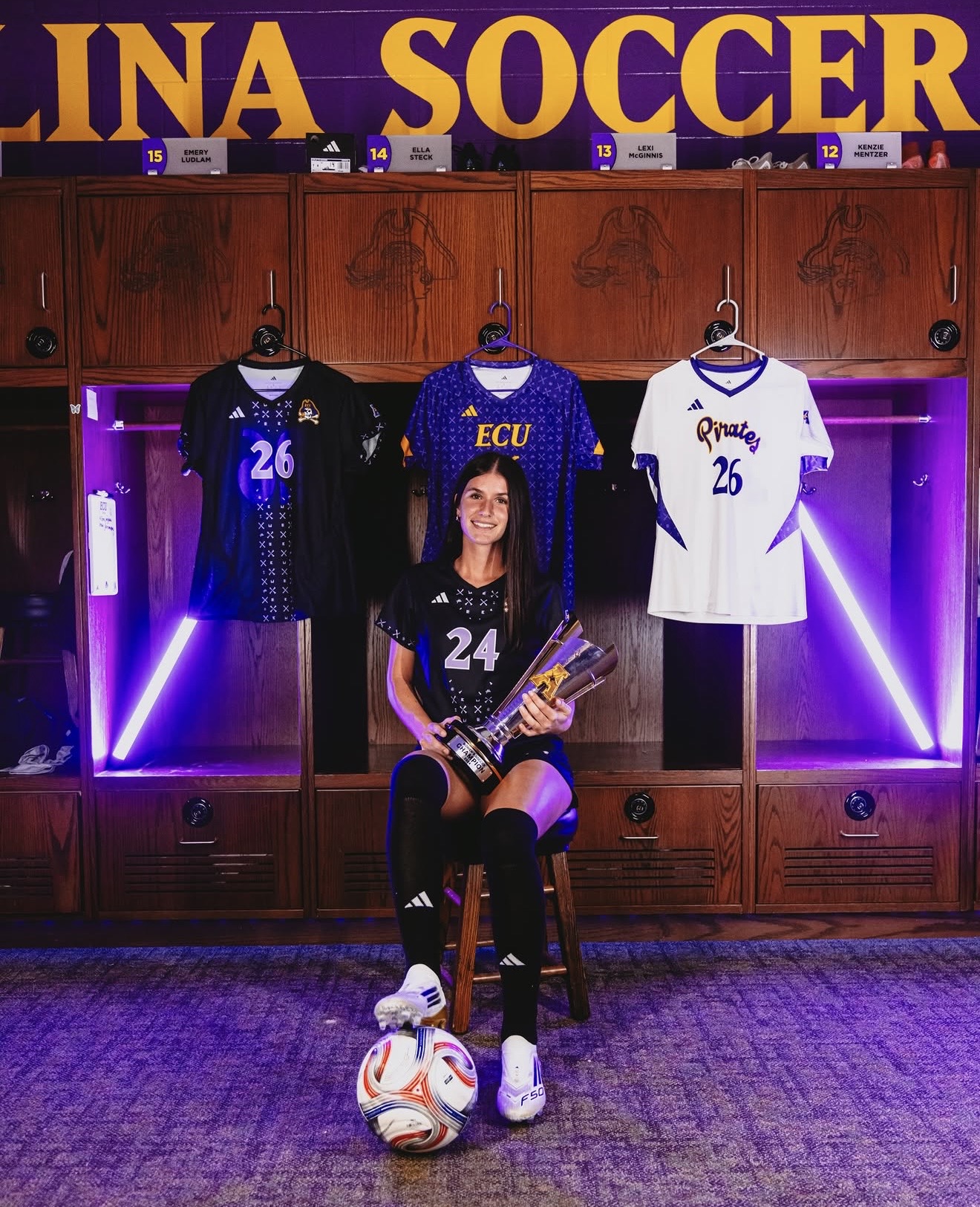 Regan Tokarz with her East Carolina University soccer jerseys and championship trophy