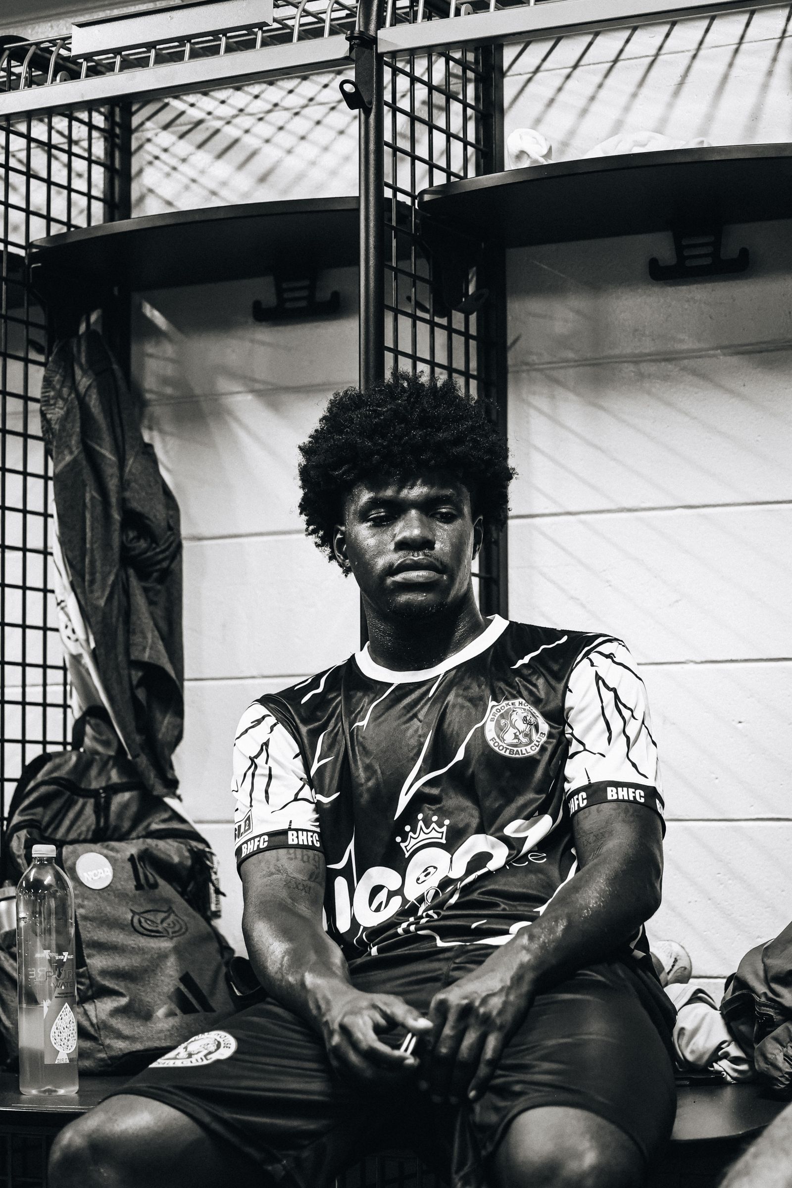 Brooke House FC player in the locker room, photographed in black and white