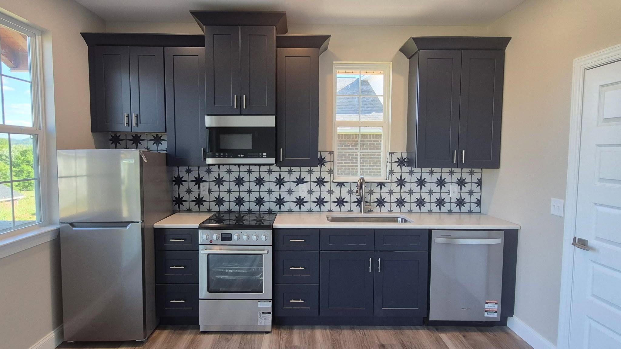 Dark kitchen cabinetry and patterned backsplash