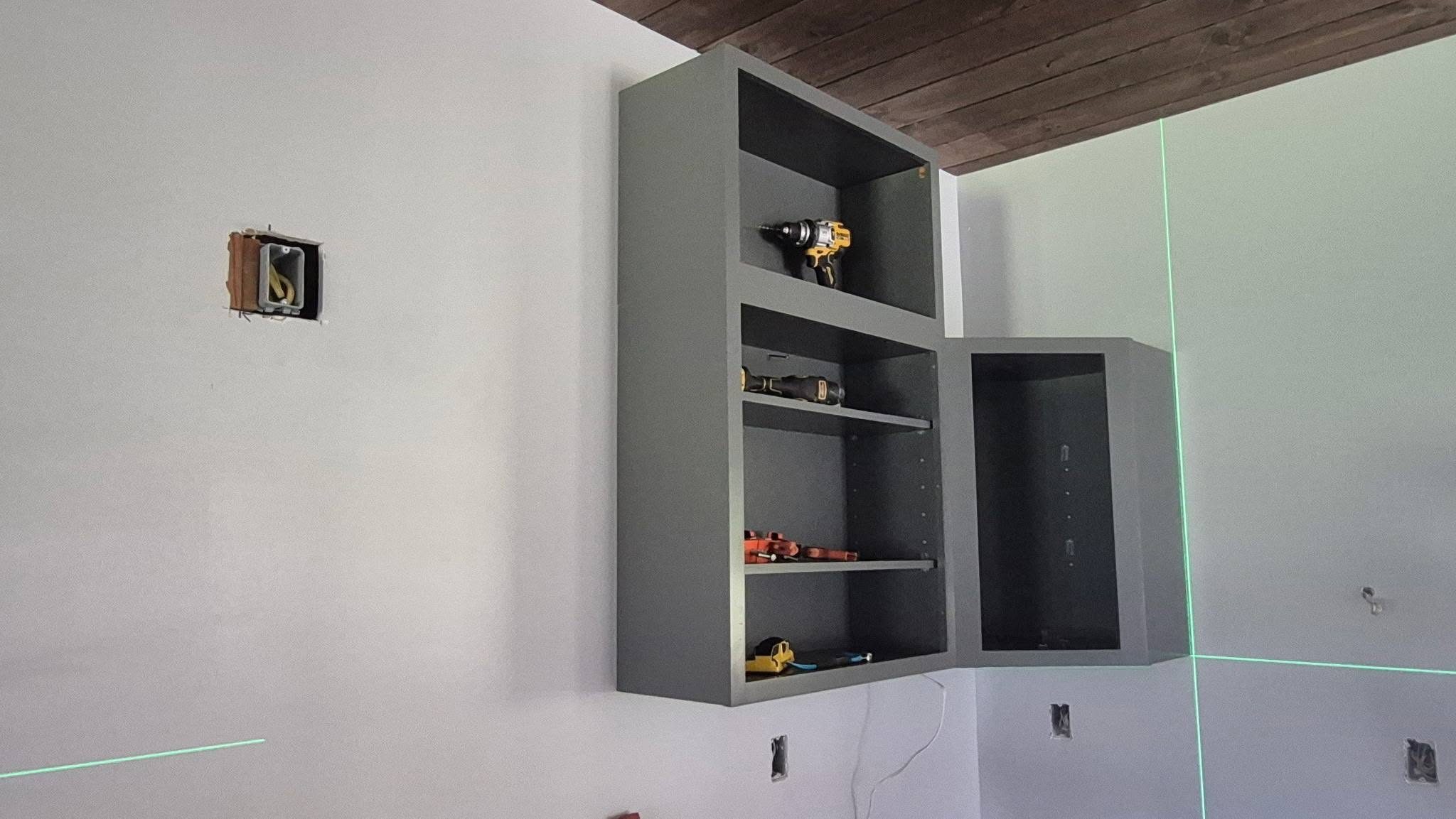 Cabinet installation in progress with laser alignment