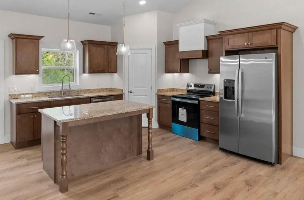 Wood kitchen cabinetry with an island and stainless appliances