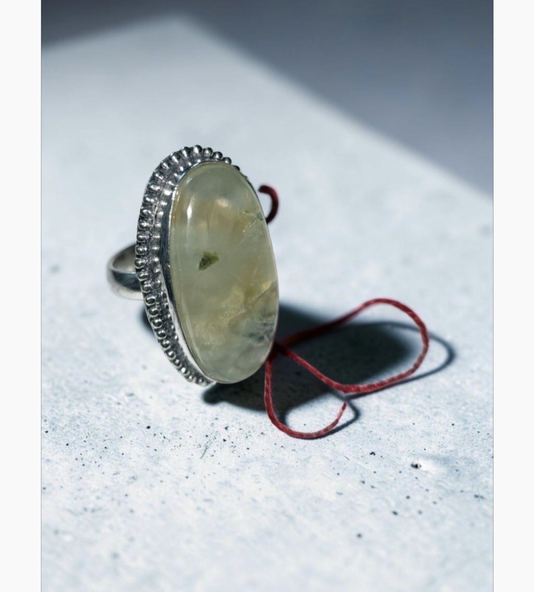 Silver ring with an oval pale green stone