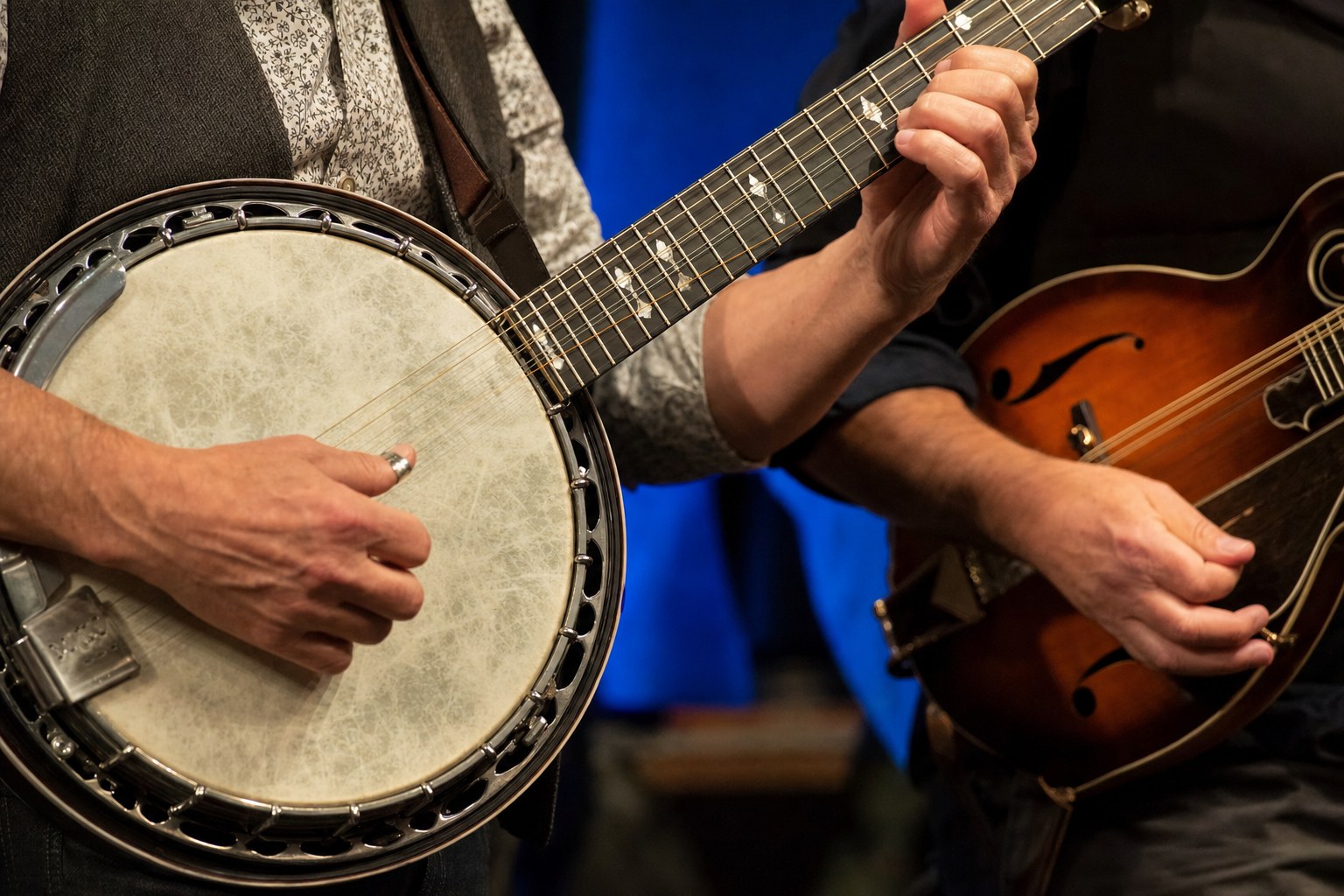 Close view of a five-string banjo and mandolin being played in an acoustic ensemble