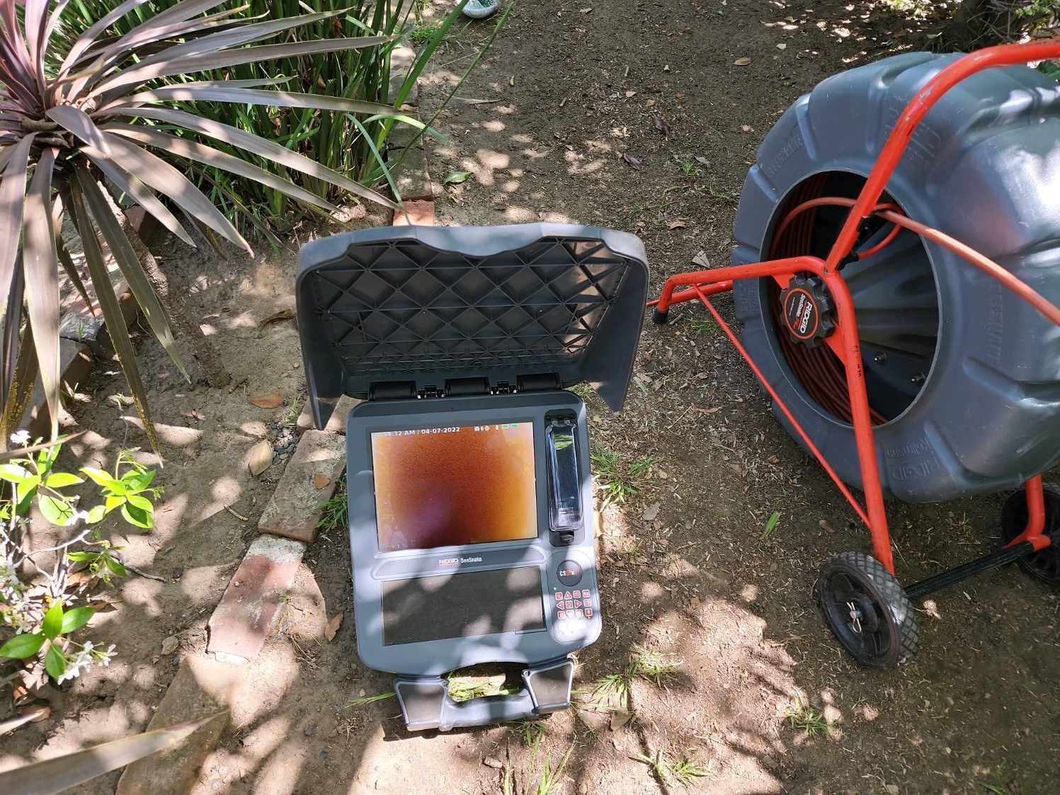 Sewer camera monitor and reel positioned at an Anytime Jetting field work site