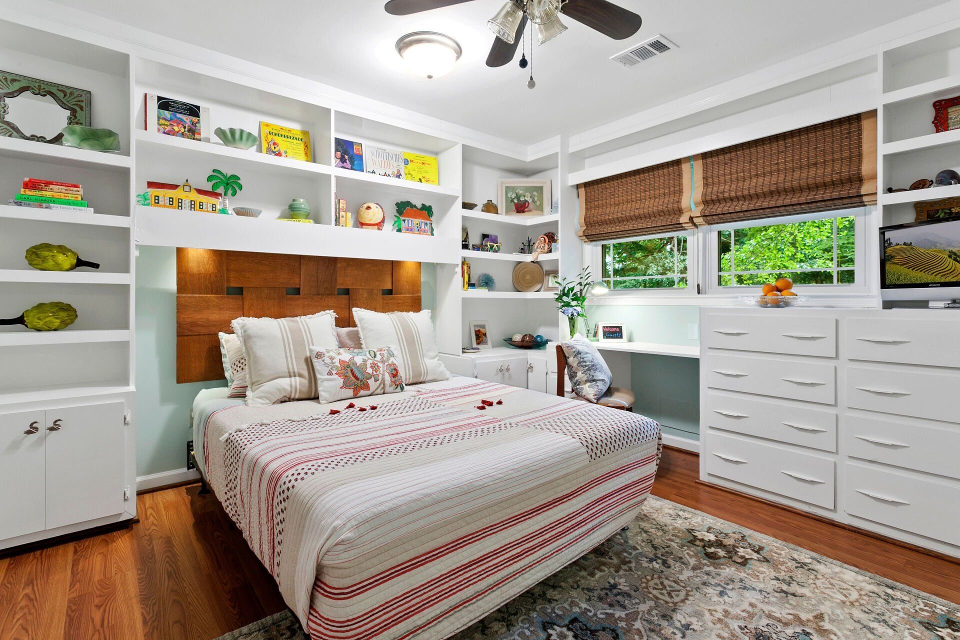 Guest bedroom with a bed, ceiling fan, and colorful accents