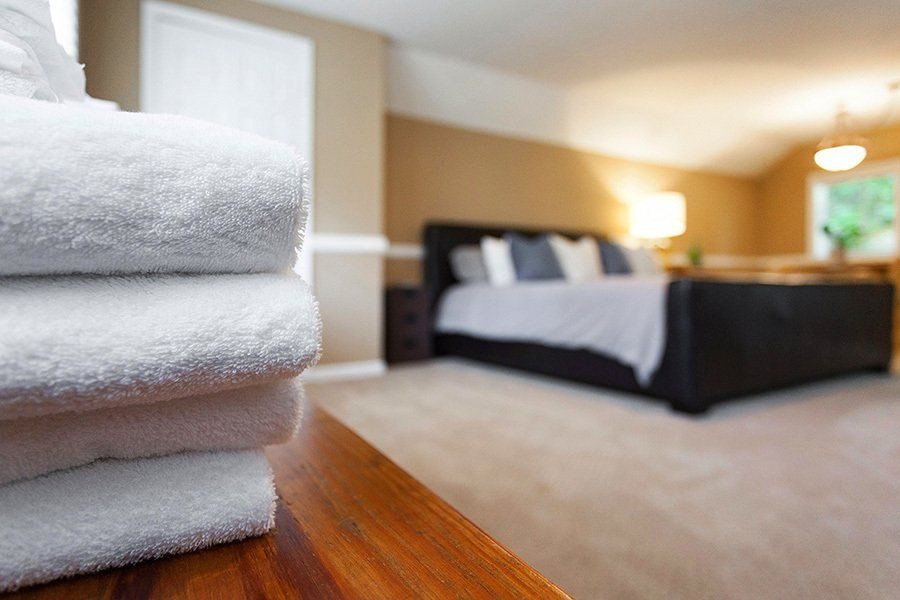 Folded towels with a guest bedroom in the background