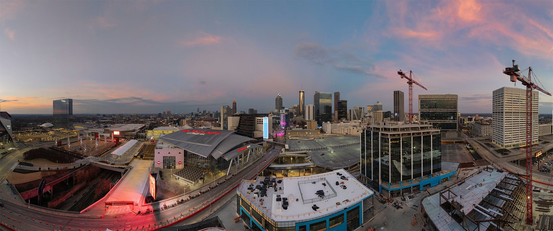 Aerial view of  Centennial Yards in Atlanta, GA at dusk with construction cranes and buildings under construction.