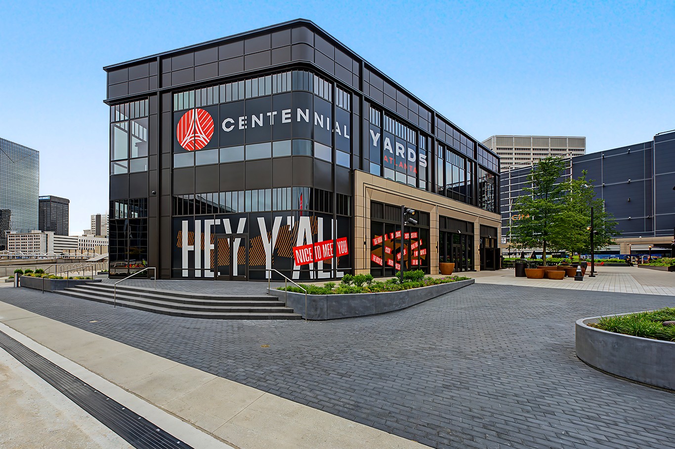 Centennial Yards Building D in Atlanta, showing the glass exterior, entrance, and landscaped plaza