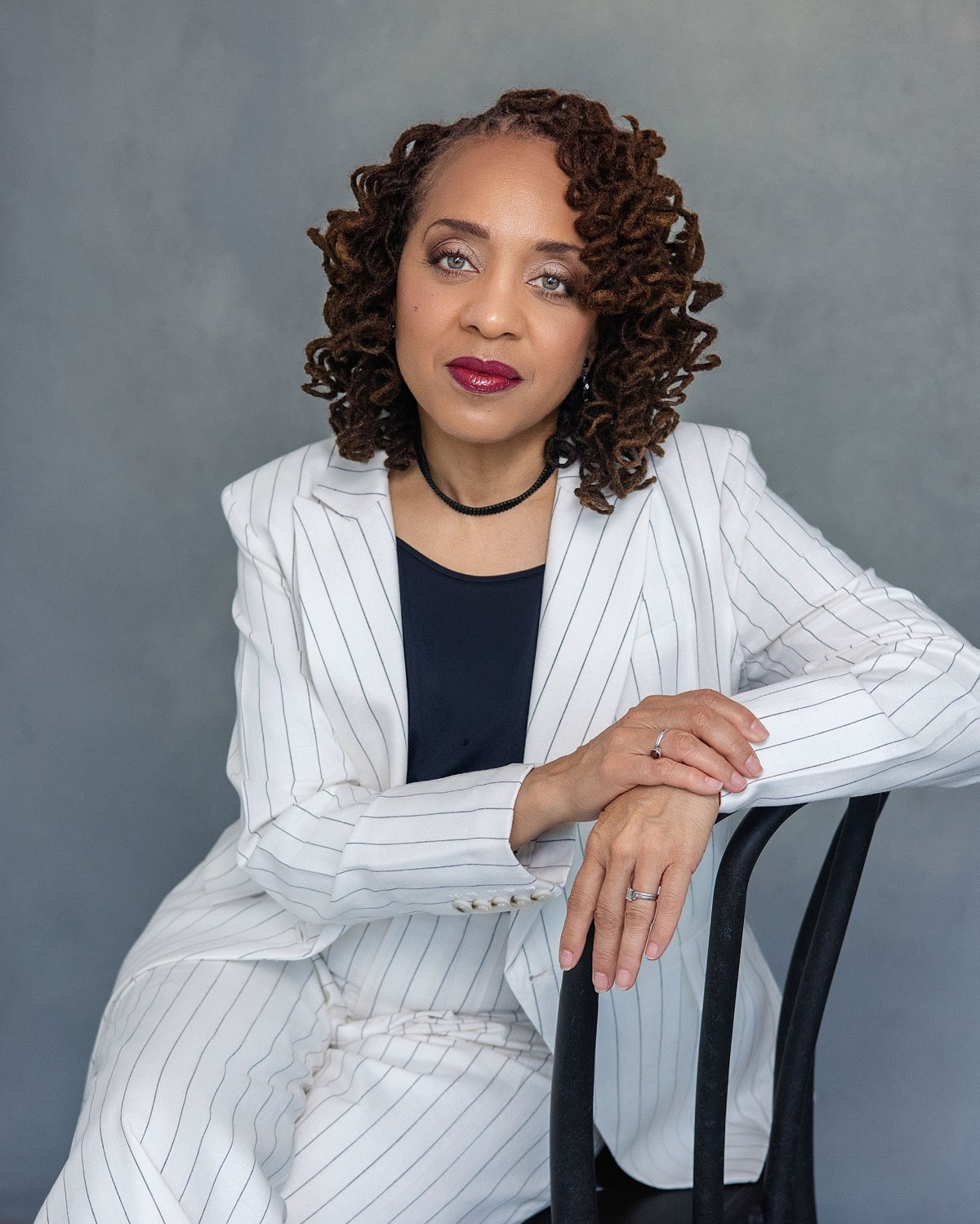 Portrait of a woman in a white pinstripe suit