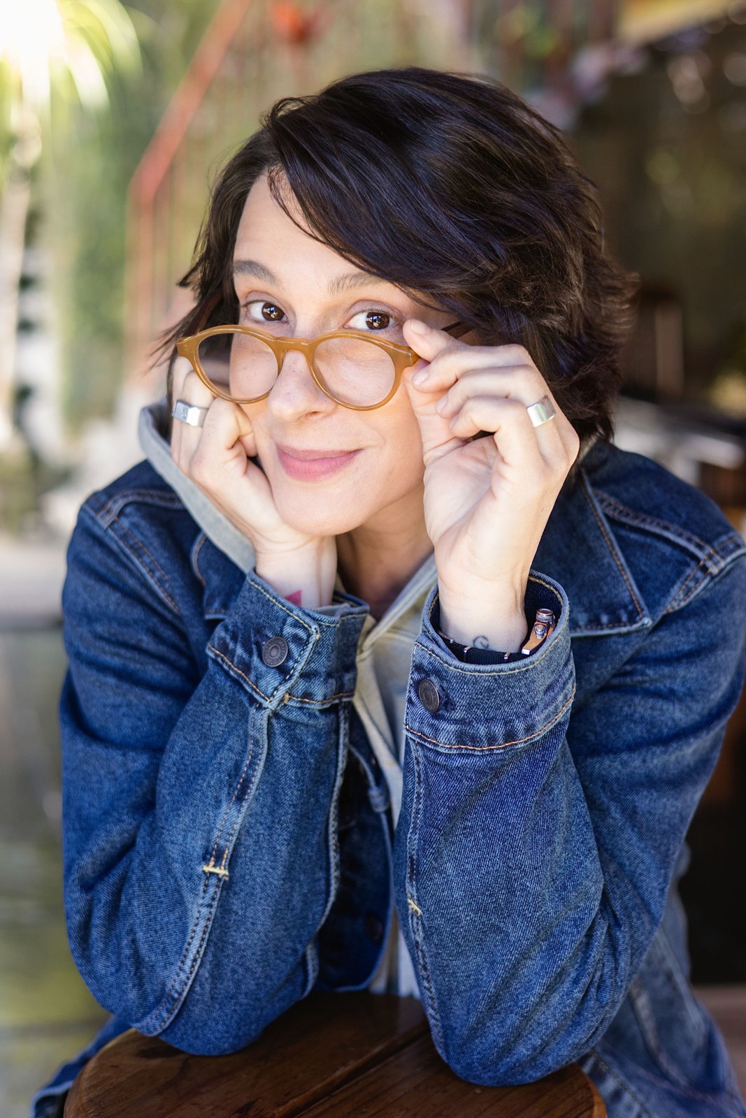 Outdoor portrait of a woman in glasses and a denim jacket