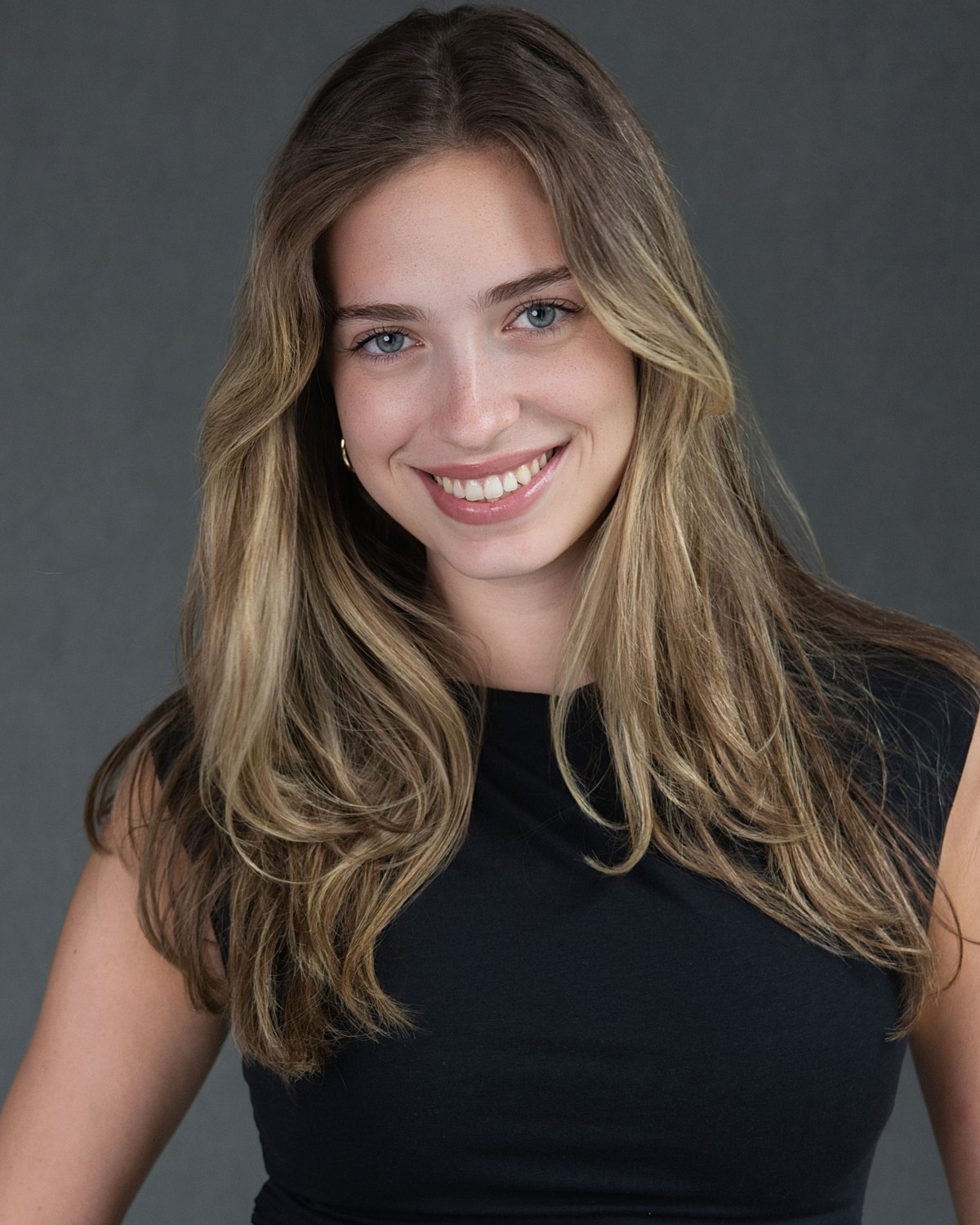 Headshot of a smiling woman in a black sleeveless top