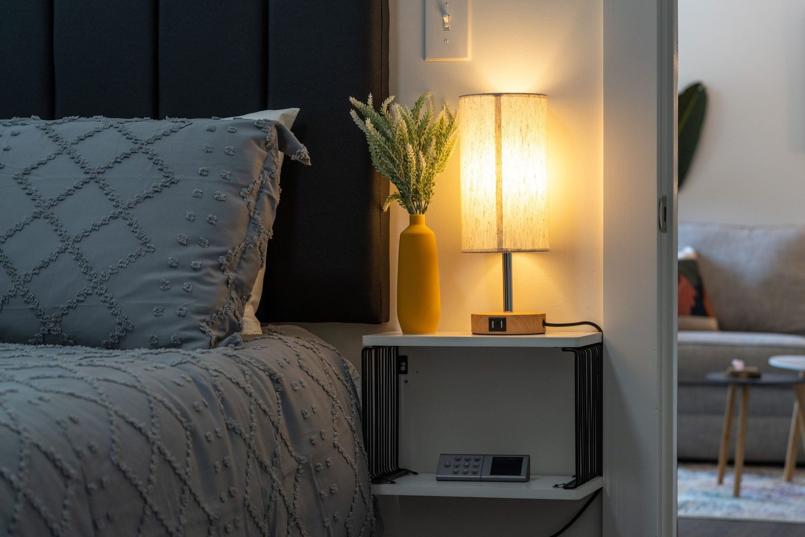 There is a lamp on the nightstand next to the bed.