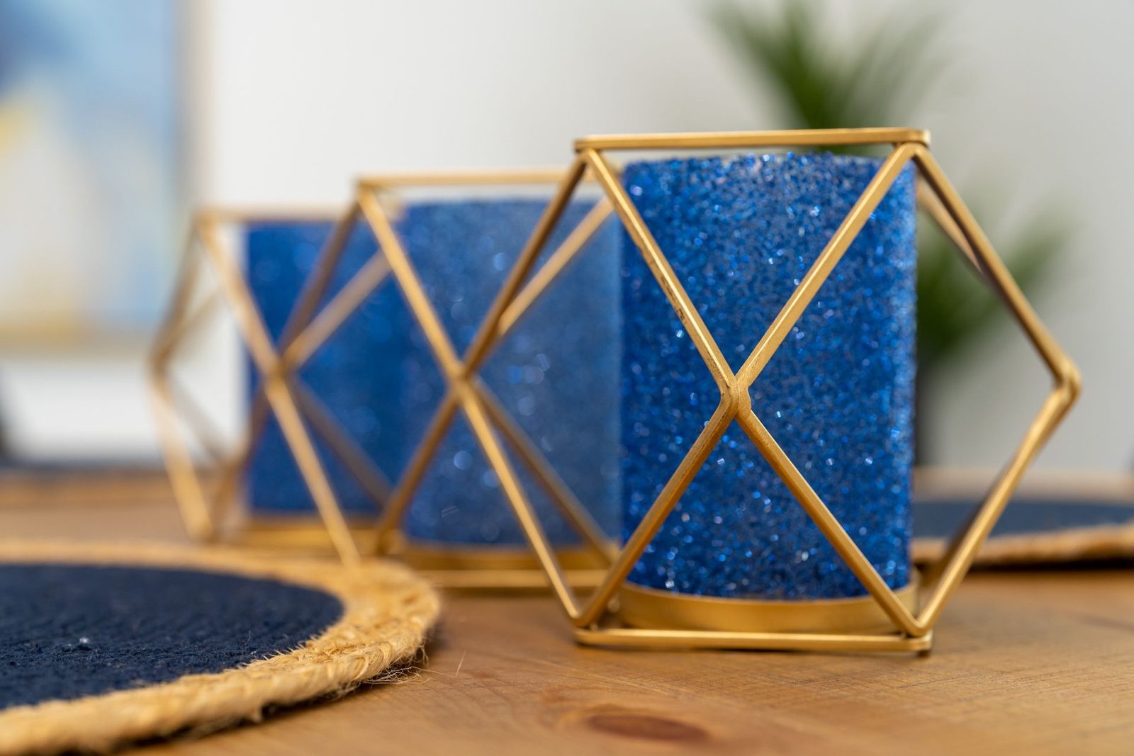 A close up of a blue candle holder on a wooden table.