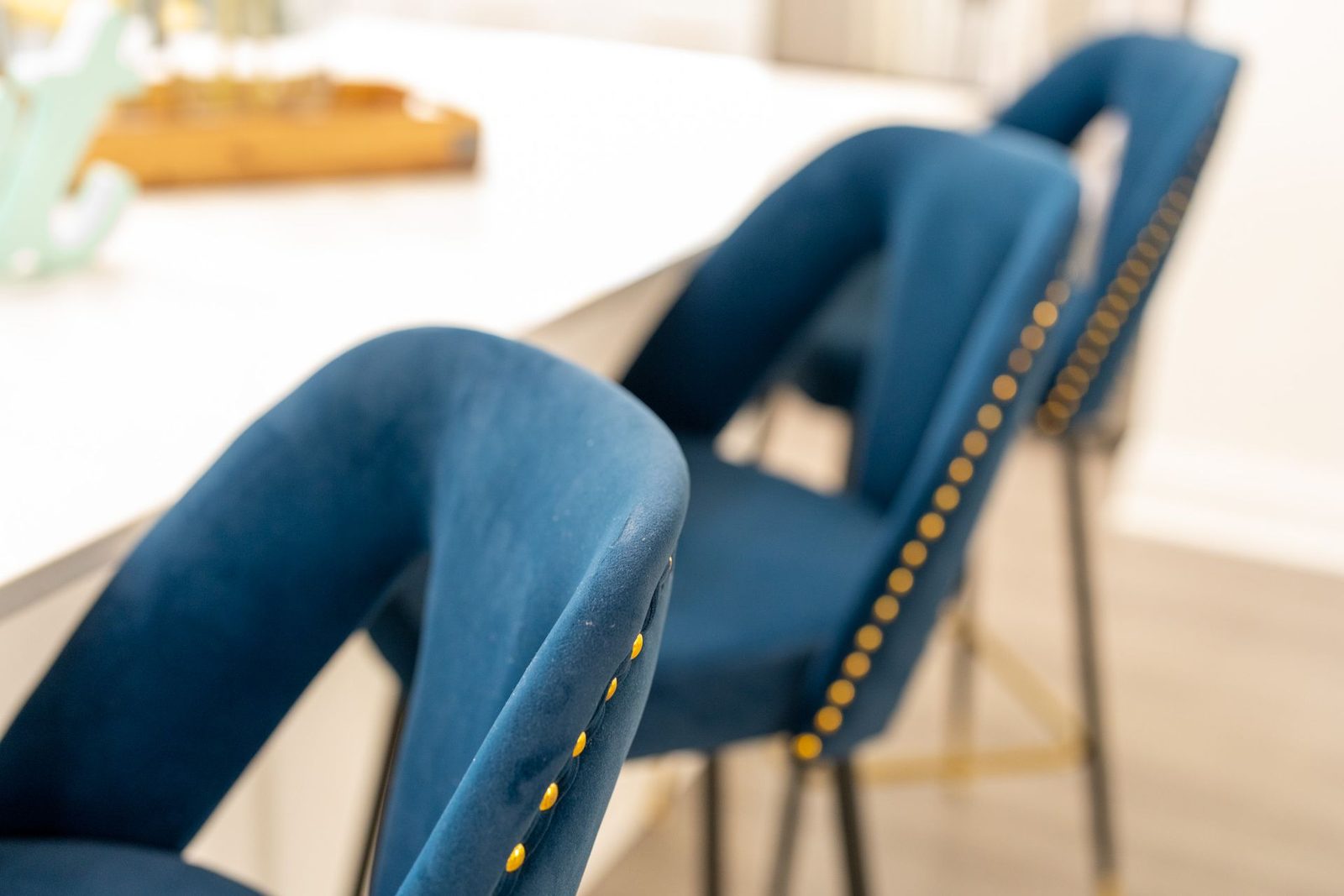 Two blue chairs are sitting next to each other in front of a white table.
